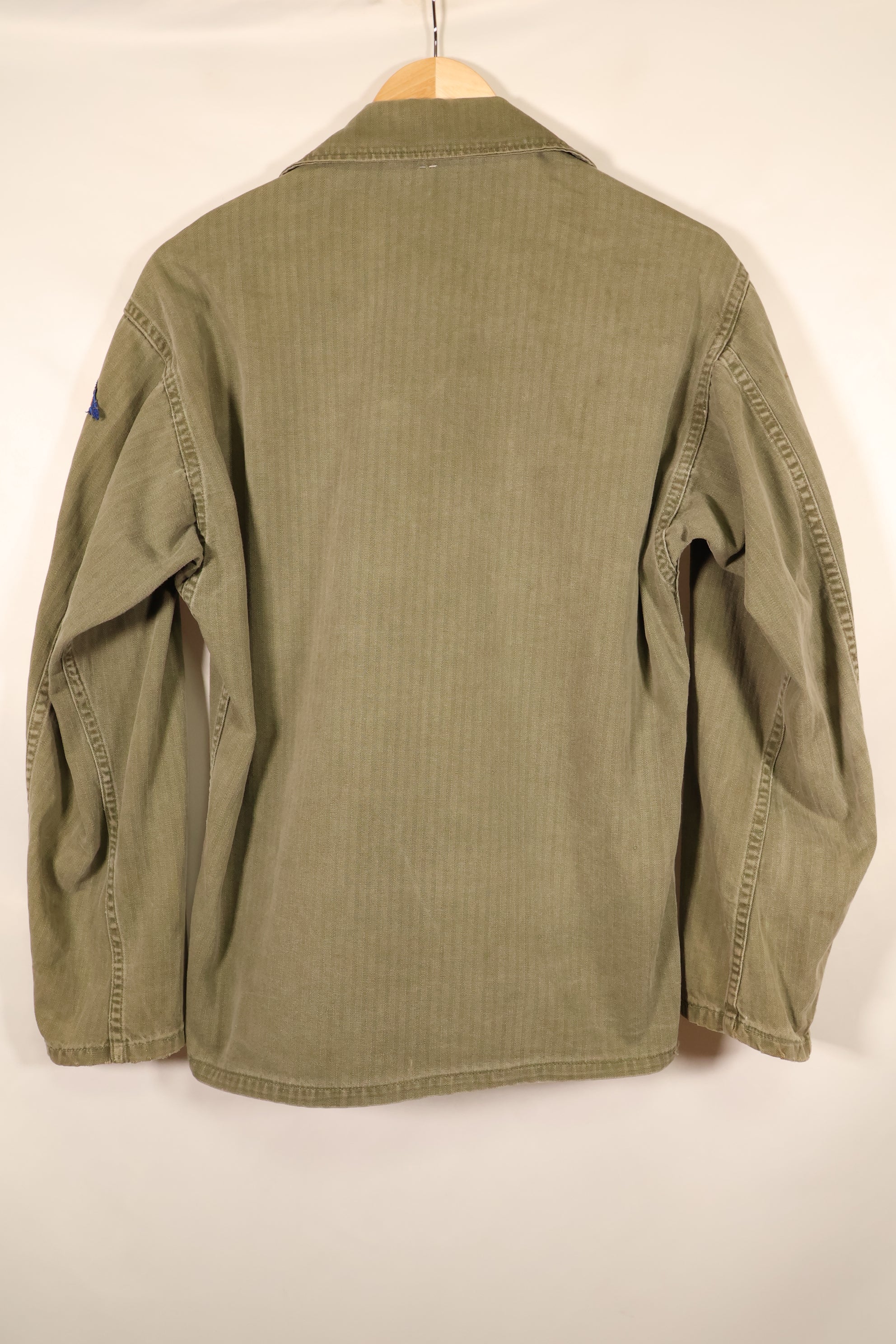 ปลายทศวรรษ 1940–1950: เสื้อยูทิลิตี้ M-47 HBT ของกองทัพสหรัฐฯ พร้อมแผ่นปะ, มือสอง